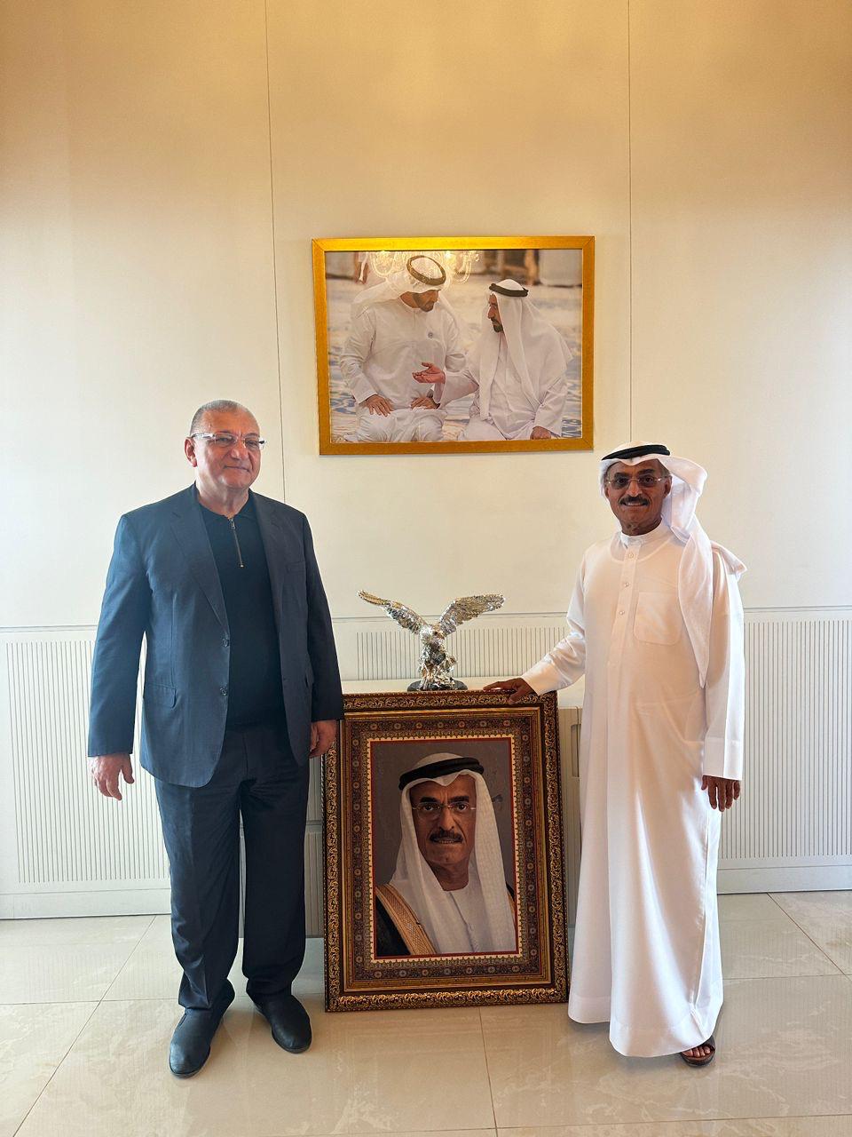 Beside the framed portrait of His Excellency